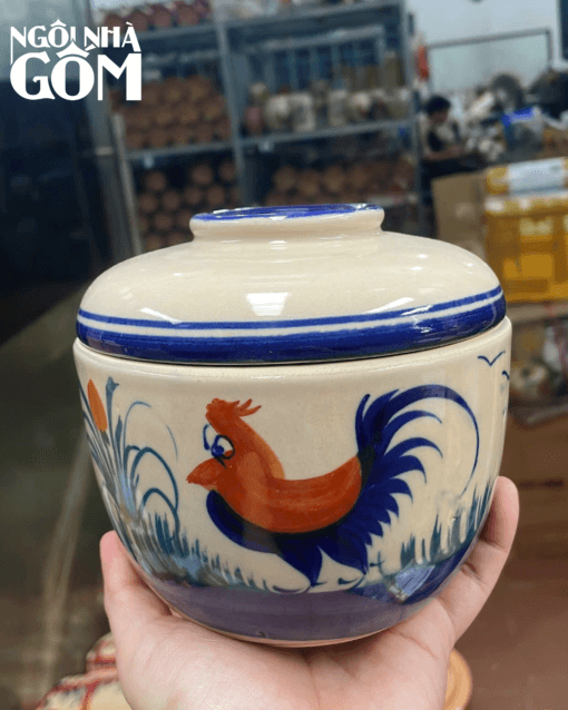 a hand holding a bowl with a bird on it